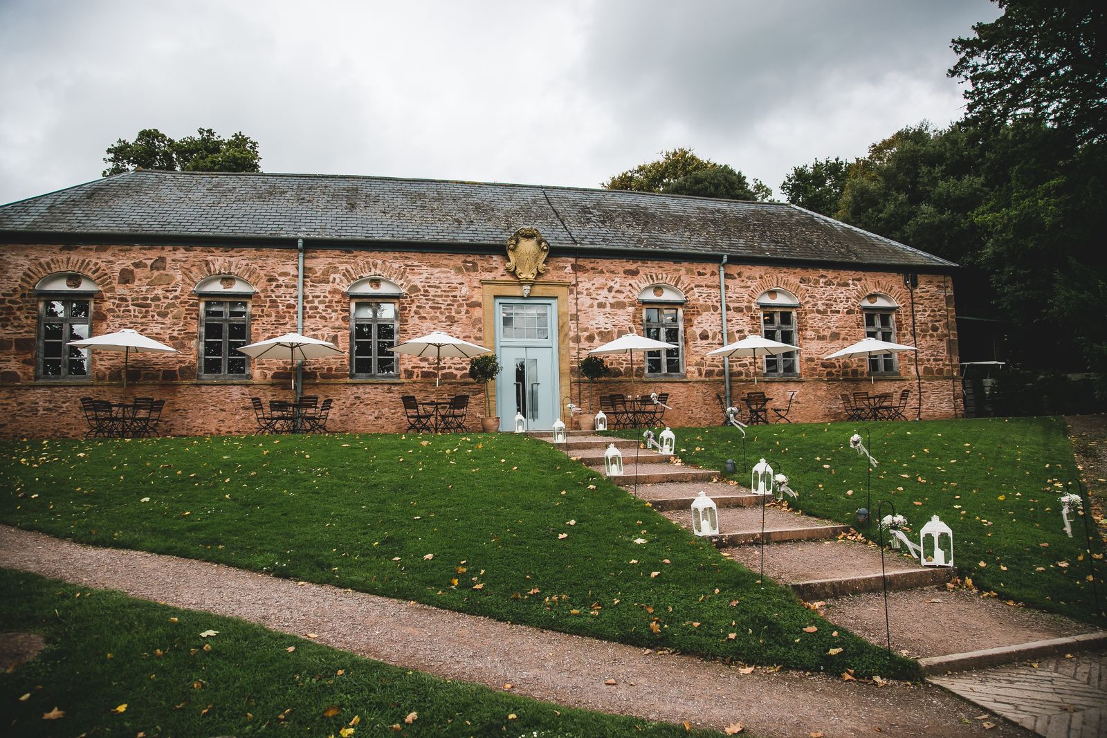 Stone barn style building with pale blue door and large windows in Somerset at Hestercombe Gardens.