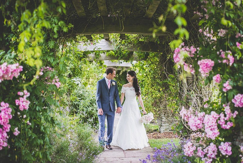 Couple walk through pergola at their Somerset wedding